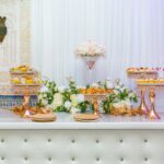 Moroccan Wedding - Elegant Moroccan wedding dessert table with traditional sweets, floral arrangements, and ornate gold stands.